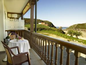 a balcony with a table and a view of the ocean at Hotel Kaype - Quintamar in Barro de Llanes