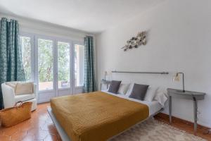 um quarto com uma cama, uma cadeira e uma janela em Kallinera em Porto-Vecchio