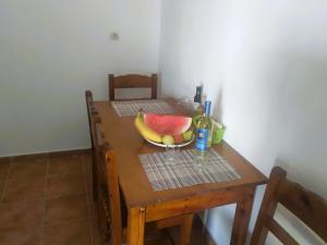 een houten tafel met een schaal fruit erop bij Aris Seaside Issos Beach in Agios Georgios +11 foto's