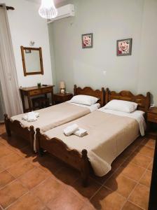 2 aparte bedden in een kamer met een spiegel bij Aris Seaside Issos Beach in Agios Georgios