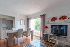 a dining room with a table and chairs and a television at Kallinera in Porto-Vecchio