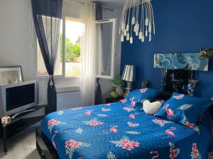 Dormitorio azul con cama y TV en ELLO HAPPINESS HOME place to be in pau, en Pau