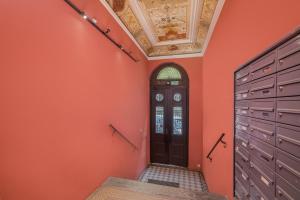 a room with orange walls and a door and a ceiling at Parkside Fresh Apartments - Old Town Guesthouse in Krakow