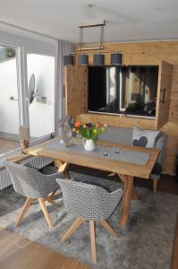 a living room with a wooden table and chairs at ALMI - Alpenglück Traumhafte Whg.m.20qm Dachterr. in Oberstaufen