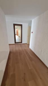 ein leeres Zimmer mit einem Spiegel und einem Holzboden in der Unterkunft Hotel San Miguel Menorca in Maó