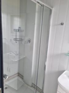 ein weißes Bad mit einer Dusche und einem WC in der Unterkunft SleepOver Moria in Moria