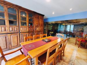 comedor con mesa de madera y sillas en Hotel Rural LAbadia de Sieste, en Sieste