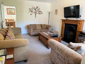 a living room with two couches and a fireplace at Cedar Place in Southwell in Southwell