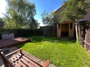 a backyard with a wooden bench and a grass yard at Cedar Place in Southwell in Southwell