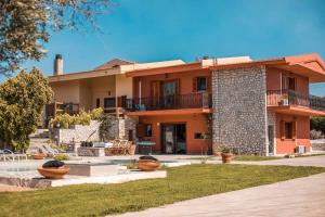 a large house with a courtyard in front of it at Wine & Vineyard Retreat Emarmene in Koskinou