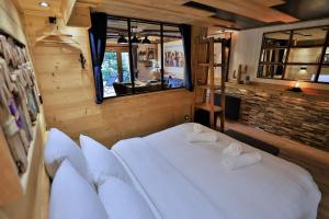 una camera da letto con un grande letto bianco e una finestra di Studio du Coin - Vue montagne, au calme, Terrasse - AravisTour a Les Villards-sur-Thônes