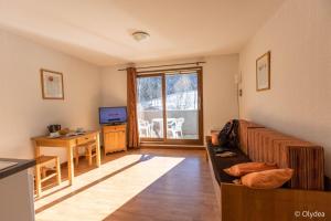 a living room with a couch and a table at Olydea les Bottieres - Saint-Pancrace in Saint-Pancrace