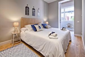 a bedroom with a large white bed with blue pillows at Habitat Apartments Barcelona Plaza in Barcelona