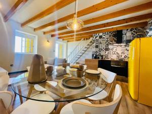 a dining room with a glass table and white chairs at Casa Flor de Sal in São Mateus