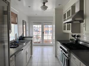 a kitchen with white cabinets and a stove top oven at The Craftsman House in Venice Beach in Los Angeles