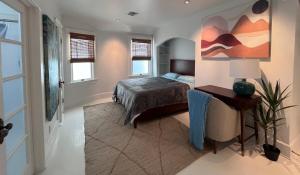 1 dormitorio con 1 cama y una pintura en la pared en The Craftsman House in Venice Beach, en Los Ángeles