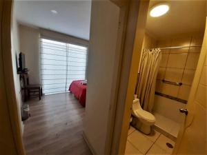 una camera con letto e servizi igienici di Kangaroo Wasi Airport Bed & Breakfast a Lima