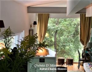 uma sala de estar com uma grande janela com uma árvore em Quinta D`Manuel Maria- Rural Charm Houses em Amarante