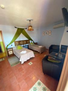 sala de estar con 2 camas y sofá en Hotel Rural La Posada de las Cigüeñas en Jerez de los Caballeros