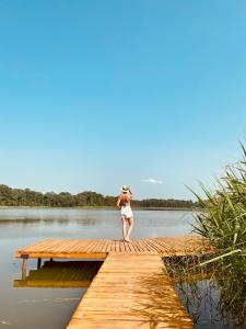 une femme debout sur un quai sur un lac dans l'établissement Siedlisko Pozorty, à Kęty