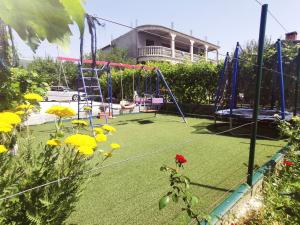 a playground in a yard with a swing at Apartment Jope in Kaštela