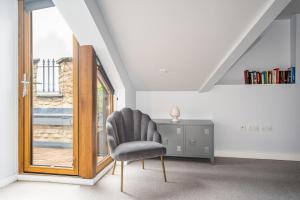 een stoel in een kamer met een bureau en een raam bij Kensington Heights in Bath