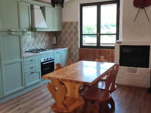 a kitchen with a wooden table and a table and chairs at Baita la Gioiosa in Livemmo
