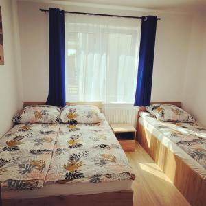 a bedroom with two beds and a window at Apartamenty Morski Brzeg - Sauna, Balia in Władysławowo