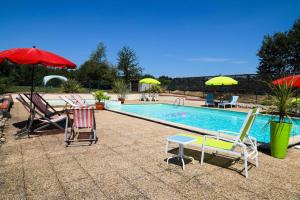 a pool with chairs and umbrellas and a table and chairs at La Grange @ Le Prielle in Madiran