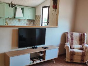 sala de estar con TV de pantalla plana y silla en Baita la Gioiosa, en Livemmo