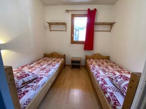 two beds in a room with a window at Appartement Brides-les-Bains, 2 pièces, 5 personnes - FR-1-512-137 in Brides-les-Bains