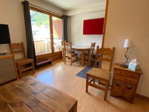 ein Wohnzimmer mit einem Tisch und Stühlen sowie ein Esszimmer in der Unterkunft Appartement Brides-les-Bains, 2 pièces, 5 personnes - FR-1-512-137 in Brides-les-Bains