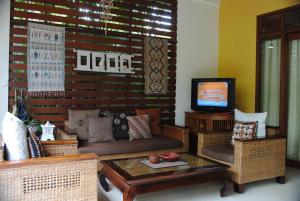 a living room with a couch and a tv at Villa Cantik in Ubud