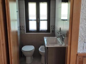 baño con aseo y lavabo y ventana en Baita la Gioiosa, en Livemmo