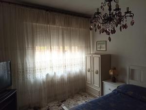 sypialnia z żyrandolem, łóżkiem i oknem w obiekcie Alba sul mare w mieście Porto Recanati +33 zdjęcia