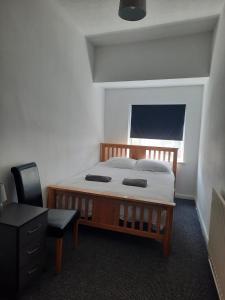 a bedroom with a bed with a desk and a chair at Alexander Apartments South Tyneside 2 in South Shields