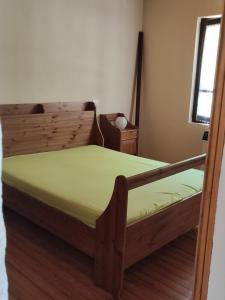 1 dormitorio con cama de madera y colchón verde en Baita la Gioiosa, en Livemmo