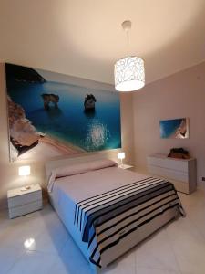 a bedroom with a bed and a painting on the wall at Caso Apartments- Holiday Houses in Poggiomarino