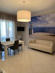 a living room with a couch and a table and a bed at Caso Apartments- Holiday Houses in Poggiomarino