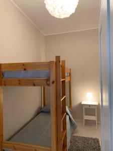 a bedroom with two bunk beds and a chandelier at Caso Apartments- Holiday Houses in Poggiomarino