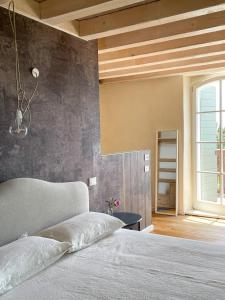 バルドリーノにあるCa Muretta Relaisのコンクリートの壁、ベッド付きのベッドルーム1室