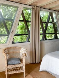 una camera da letto con una grande finestra con un letto e una sedia di Ca Muretta Relais a Bardolino
