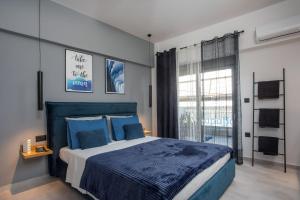 a bedroom with a blue bed and a large window at Rhodes Diamond luxury flat in the heart of town in Rhodes Town