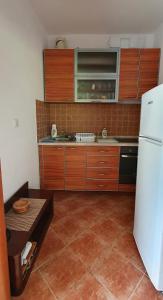 a kitchen with wooden cabinets and a white refrigerator at Villa Sunrise in Herceg-Novi