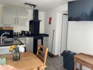 a kitchen with a wooden table and a kitchen with a stove at Mallard s Retreat in Blandford Forum