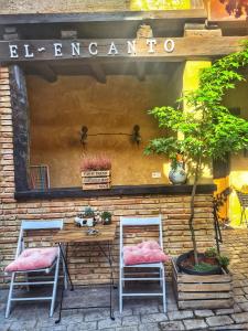 una mesa y dos sillas frente a una tienda en Albergue El Encanto en Villares de Órbigo