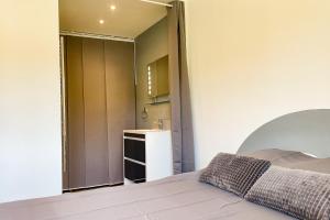 1 dormitorio con cama, lavabo y espejo en FRANCESCA, Plage à pied, Terrasse, Clim - Porticcio en Porticcio