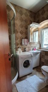 uma casa de banho com uma máquina de lavar roupa e um lavatório em Villa Sunrise em Herceg Novi
