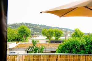 een uitzicht op een tuin met een parasol bij FRANCESCA, Plage à pied, Terrasse, Clim - Porticcio in Porticcio