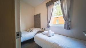 Giường trong phòng chung tại Hazel Oaks, Beautiful Lodge with Hot Tub - Sleeps 6 - Felmoor Park